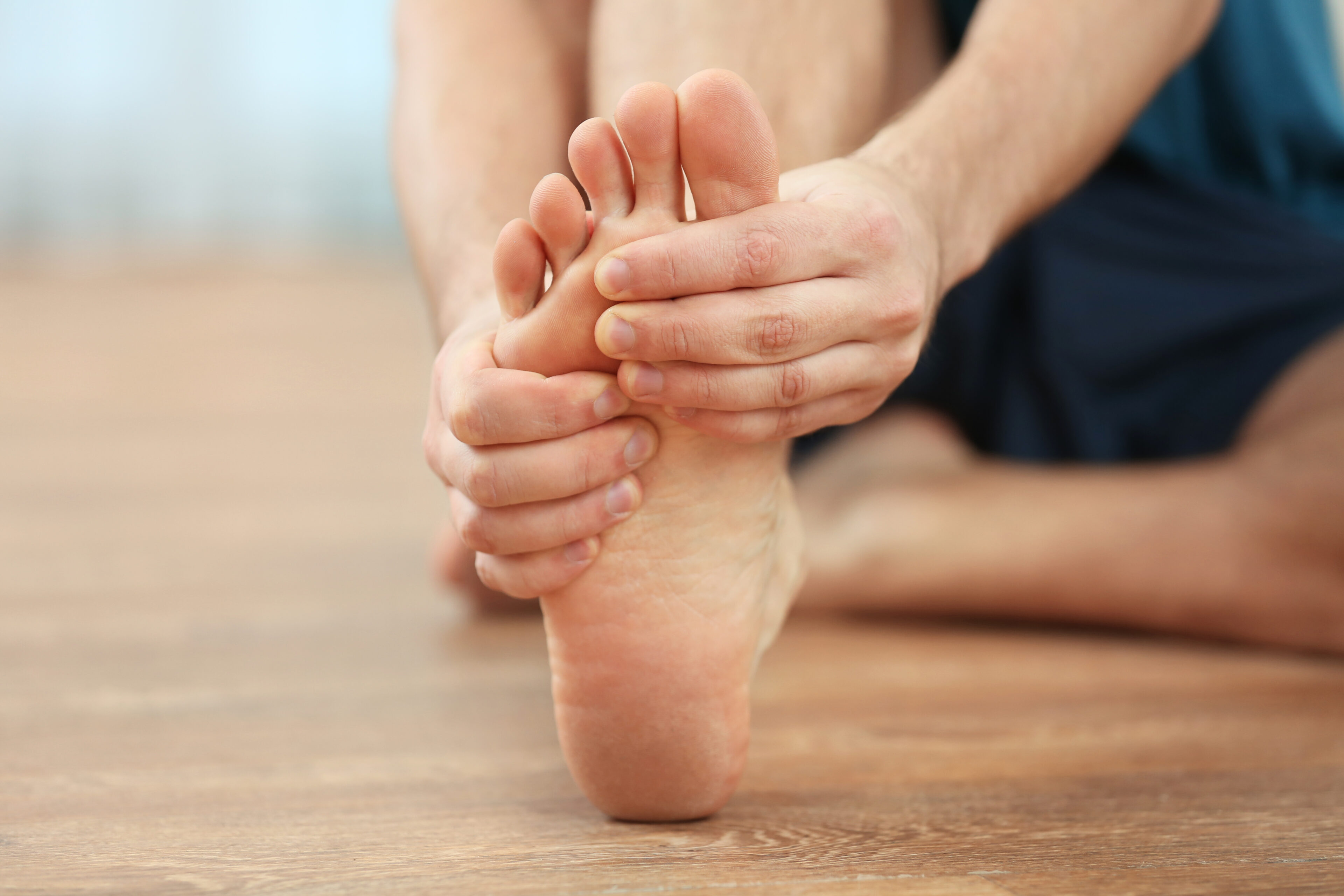 man suffer from podalgia and holding his foot