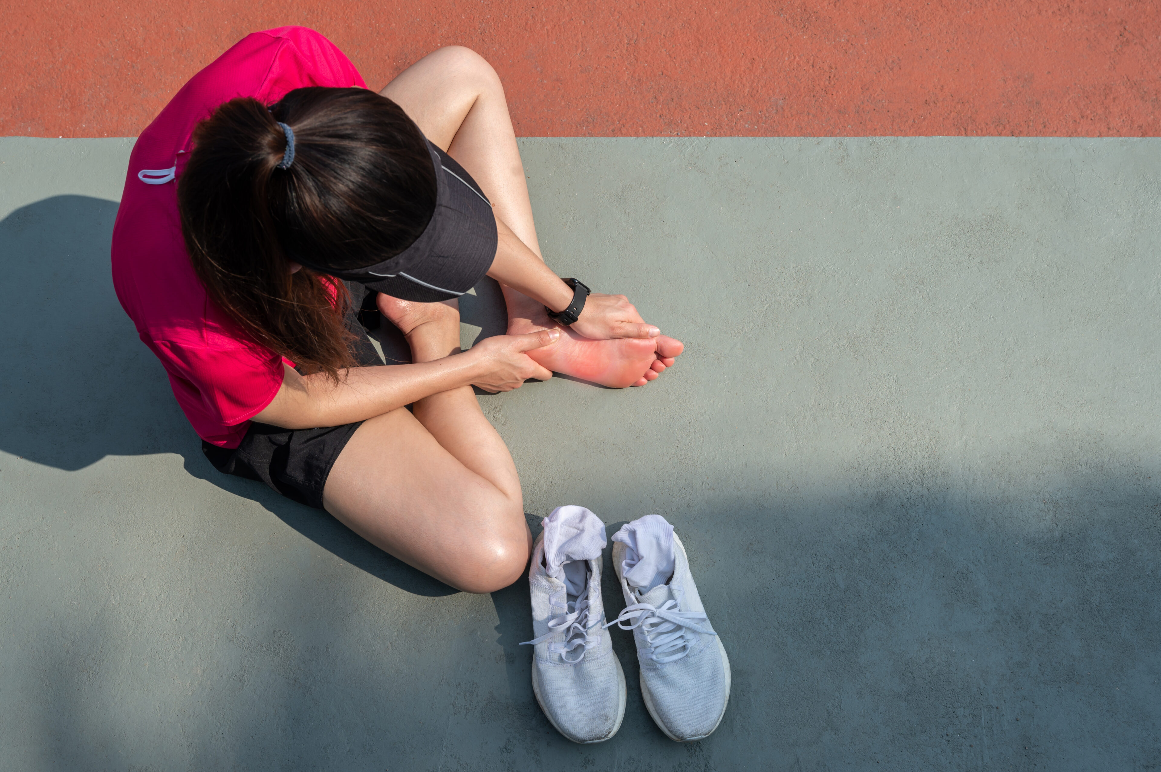 a women runner suffer from injury on foot and doing foot massage