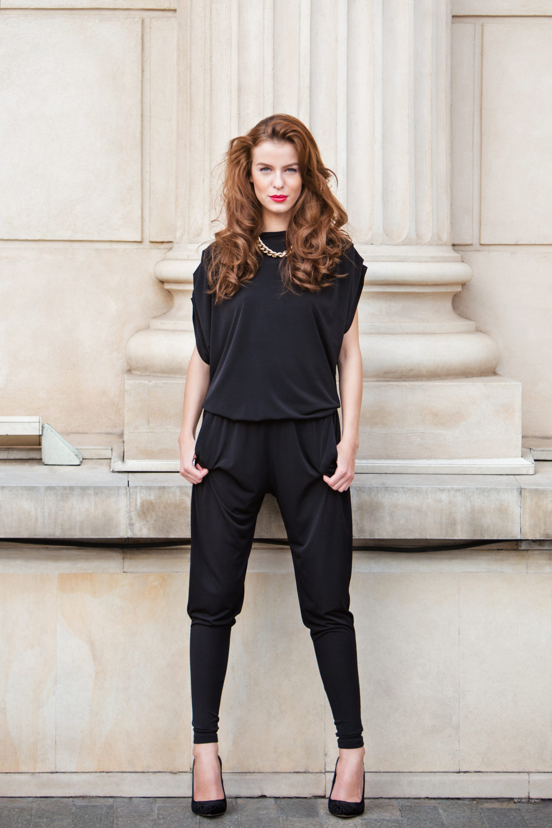 A Tailored Jumpsuit In A Solid Color With Minimal Accessories And Black Heels